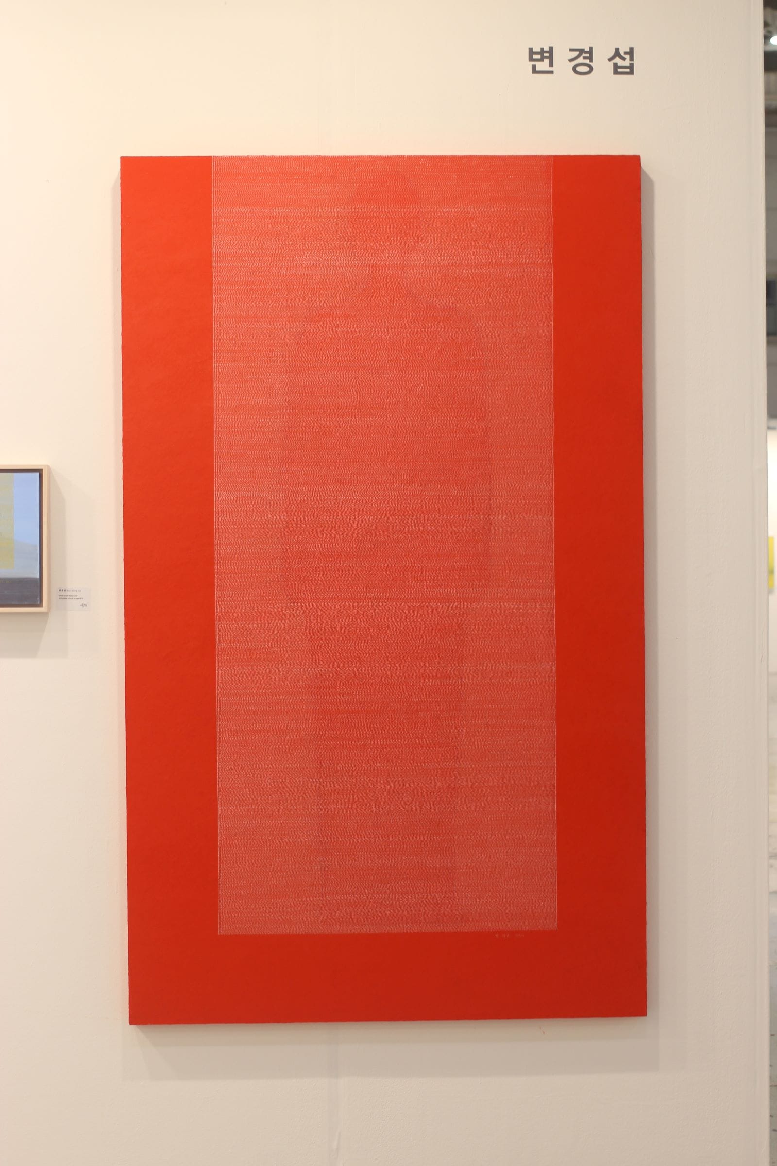 A barely visible red human form on a red background, with ultra thin horizontal lines forming a translucent rectangle in front.