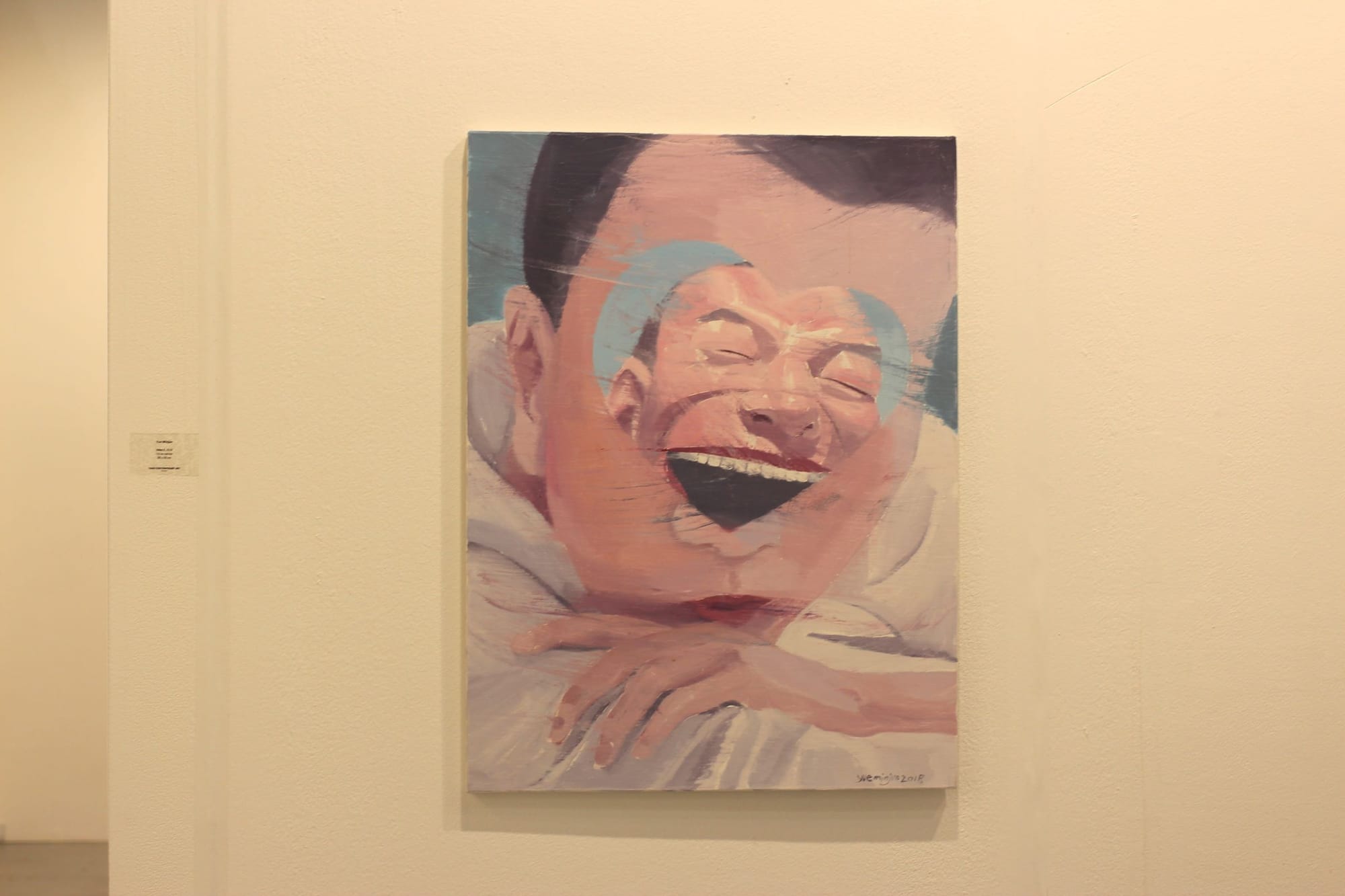A person half-pouts, resting his head on his arms. A painted heart-shaped "cutout" obscures his eyes, revealing another person, possibly also him, laughing maniacally.