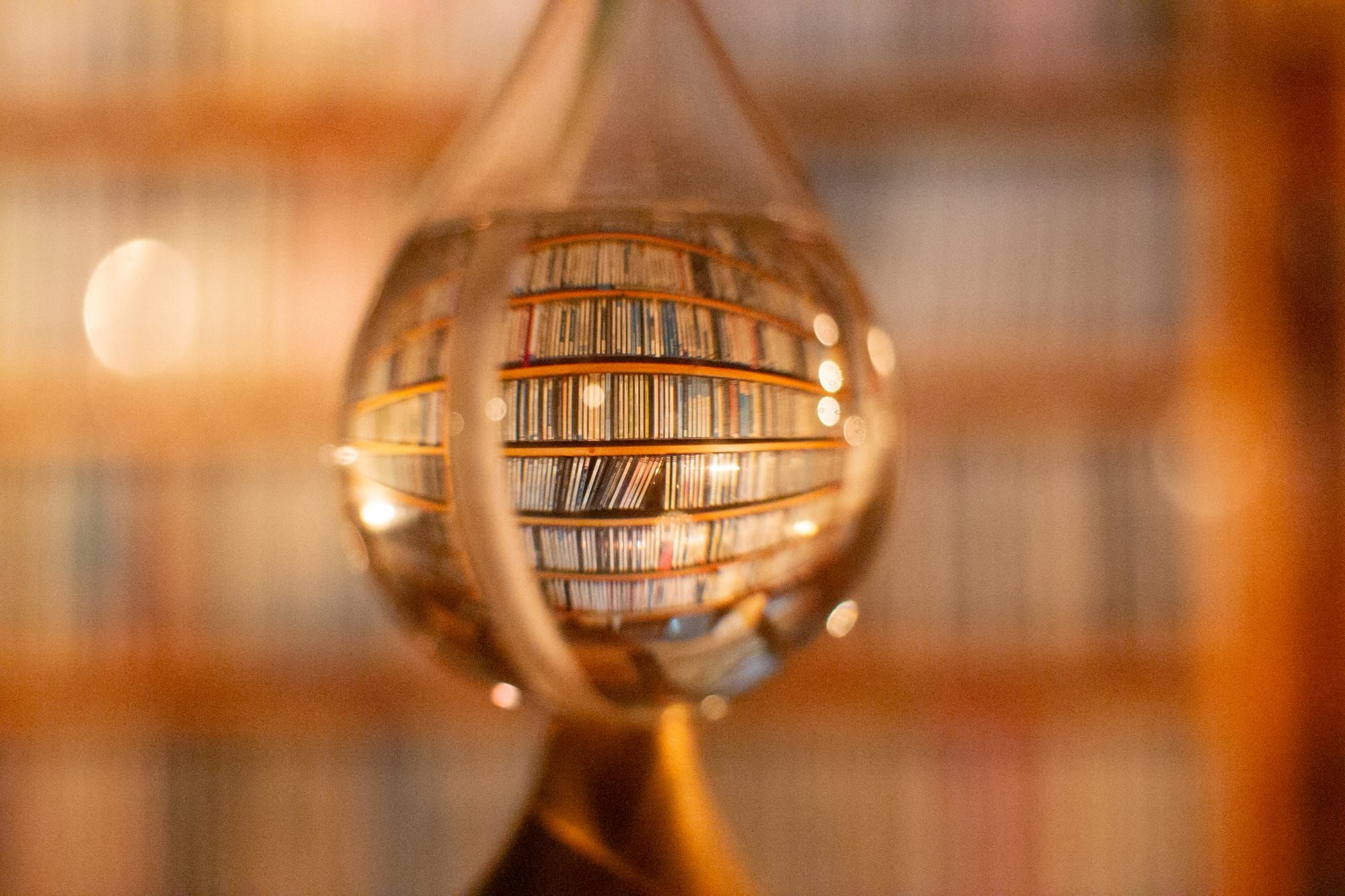 A fisheye lens effect created by a teardrop-shaped glass bulb, showing filled shelves of CDs.