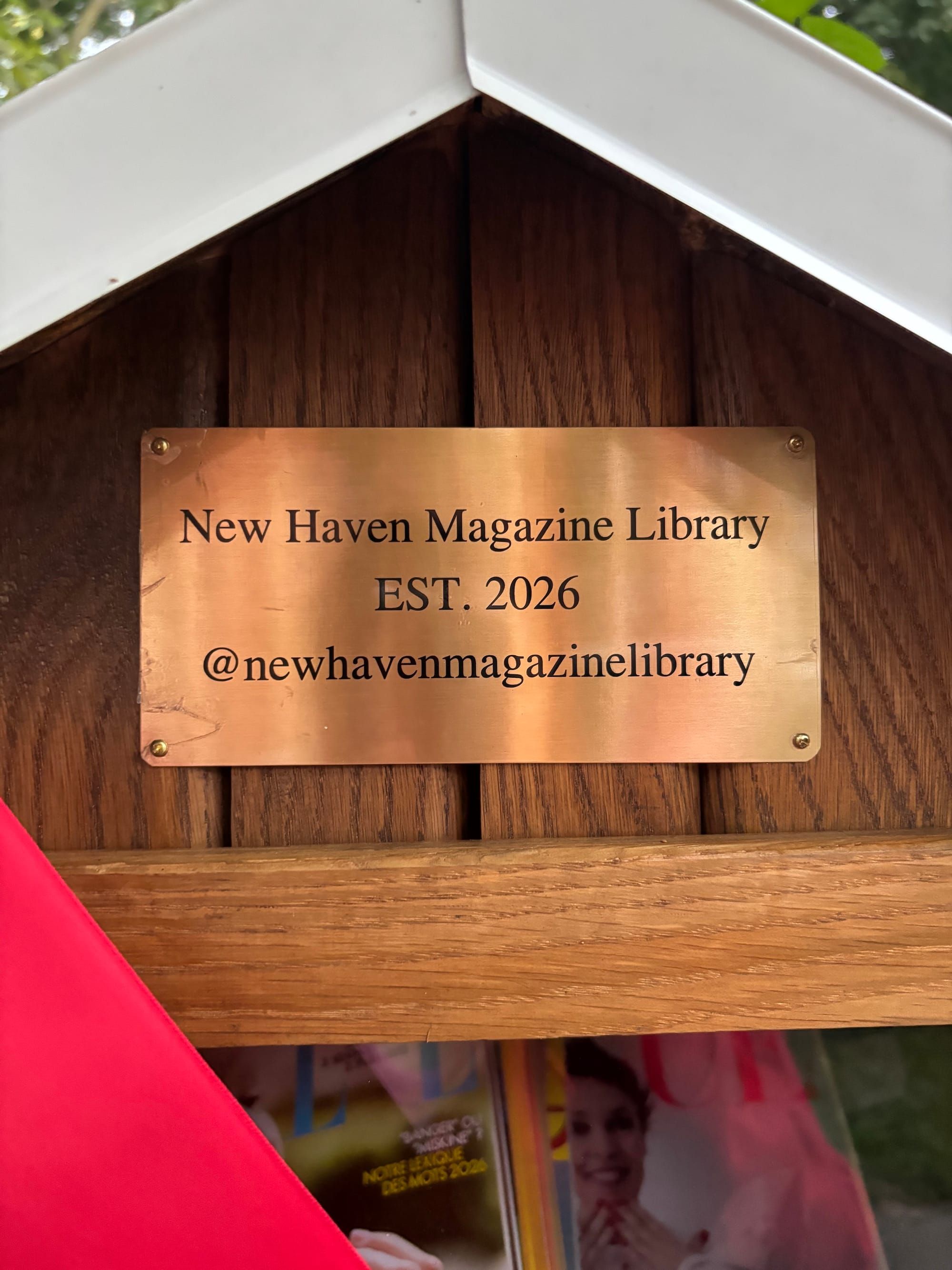 A photo of a metal plate on the library, with the words, "New Haven Magazine Library/EST. 2026/@newhavenmagazinelibrary"