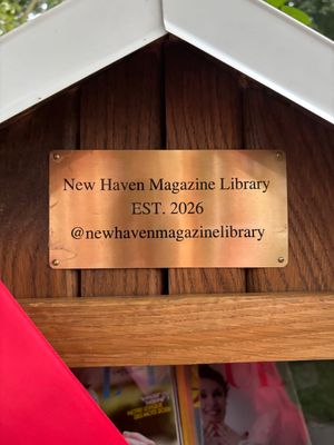 A photo of a metal plate on the library, with the words, "New Haven Magazine Library/EST. 2026/@newhavenmagazinelibrary"