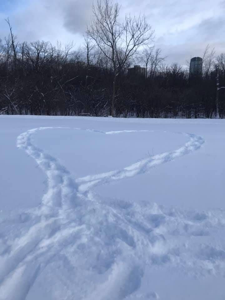 a snowy field with a heart made out of snowshoe tracks