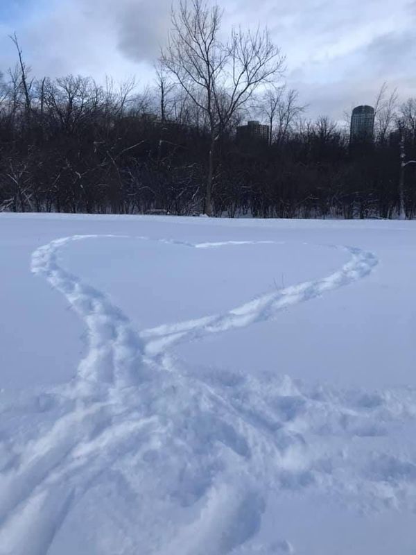 a snowy field with a heart made out of snowshoe tracks