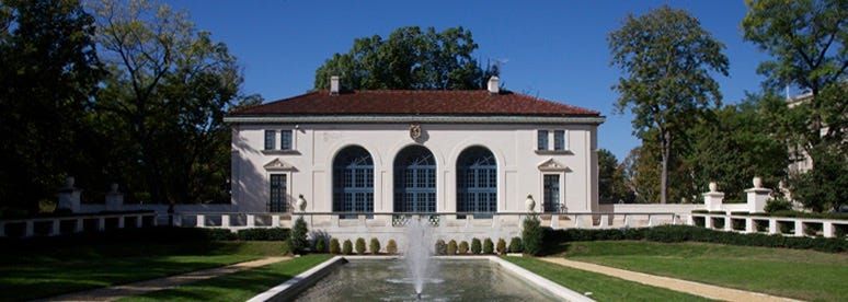 The Art Museum of the Americas in Washington, D.C., a historic white stucco building with a red-tiled roof and large arched w