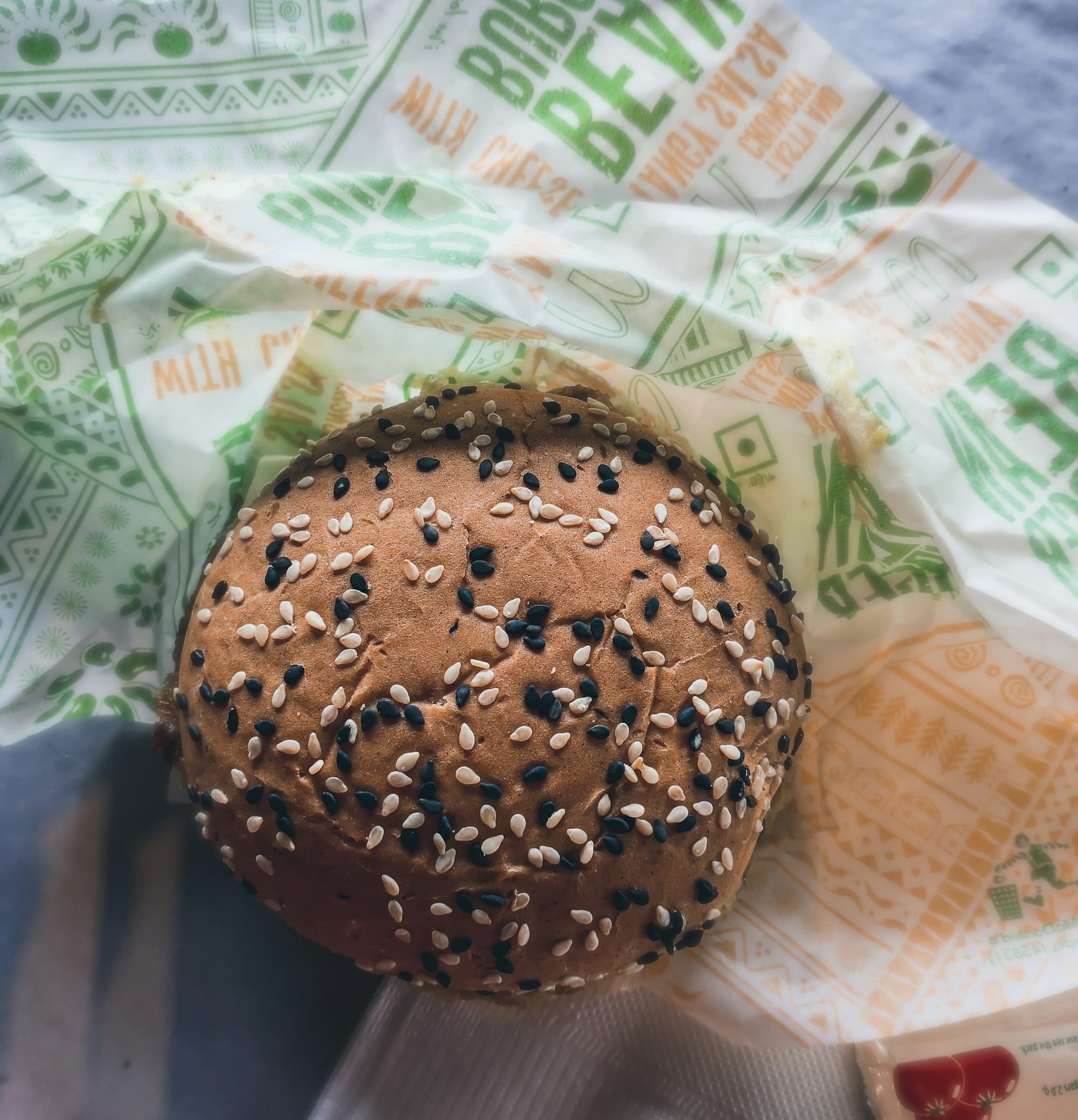 a bagel with sesame seeds on it sitting on a napkin