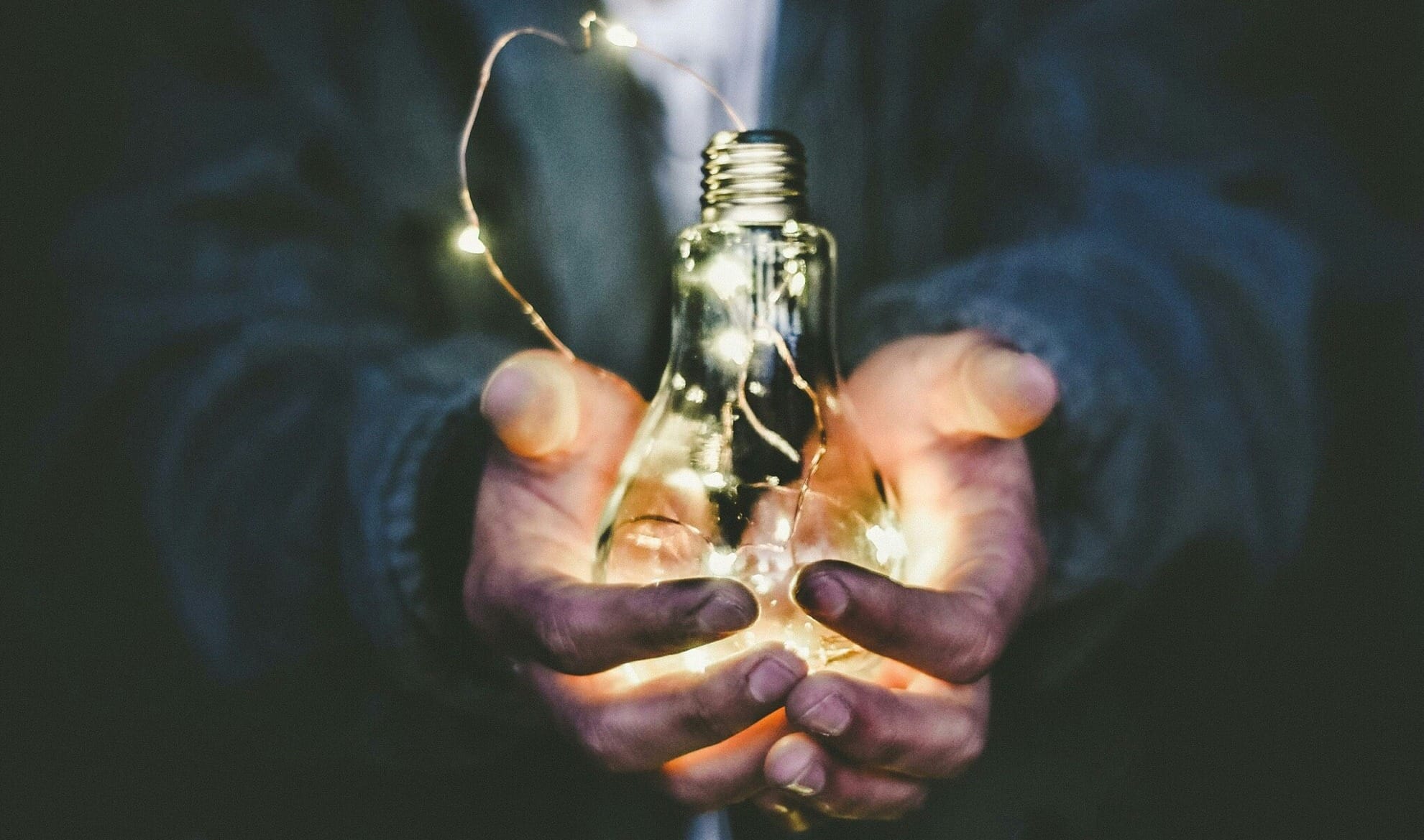man holding incandescent bulb