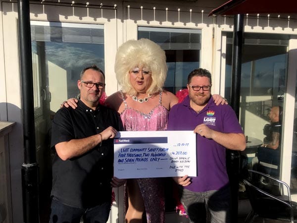 Barry Nelson and Davina Sparkle present cheque to Gavin Kerruish from LGBT Community Safety Forum for £4,207.