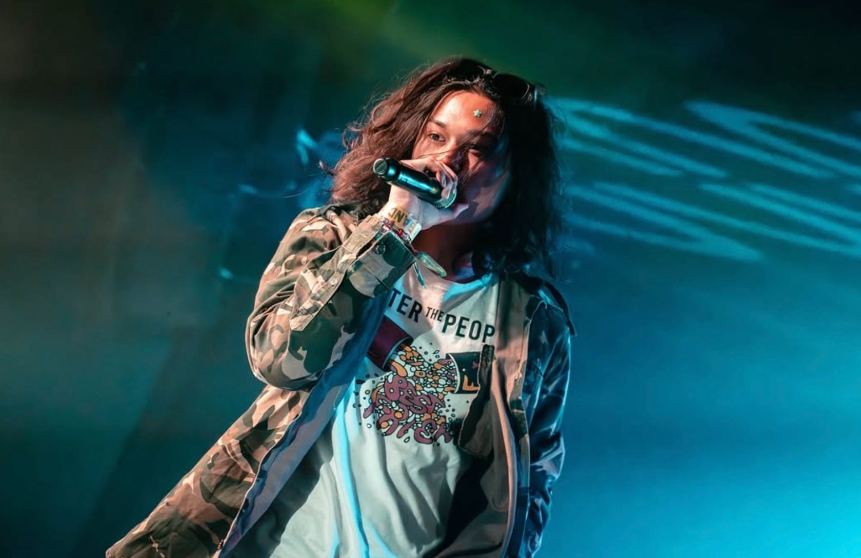 Feng at Band On The Wall performing on stage with blue lights in the background