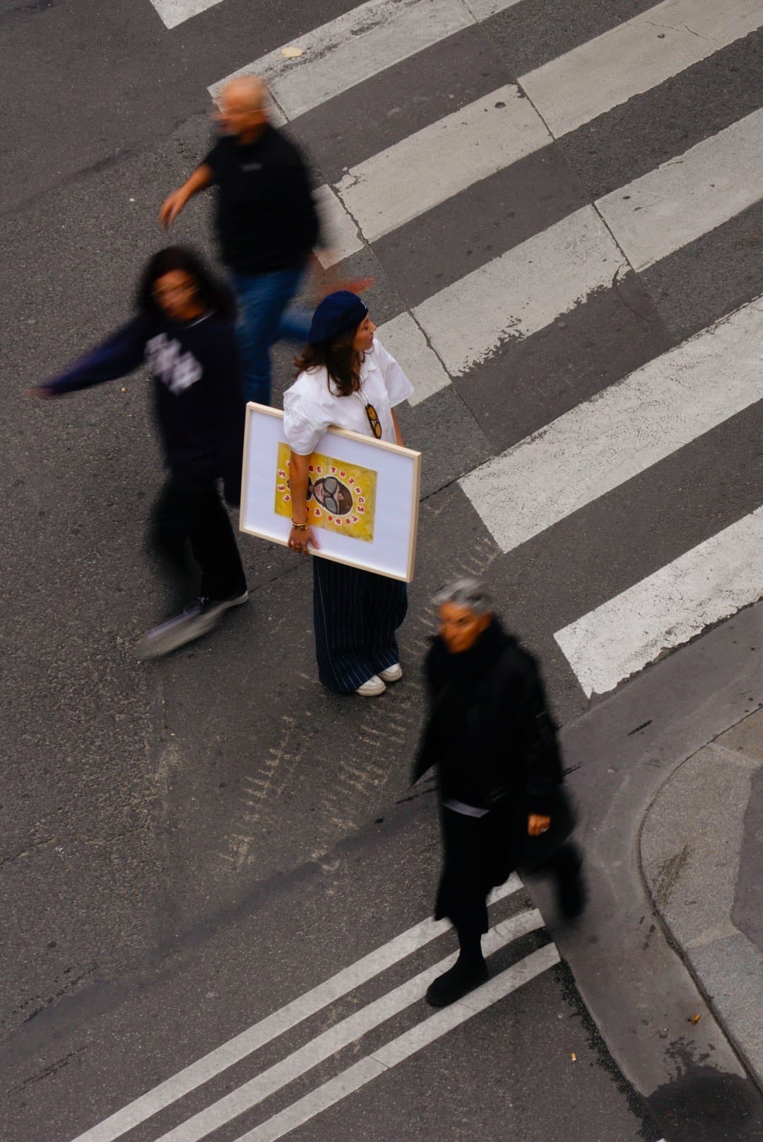An artist stood in the middle of the road holding her artwork