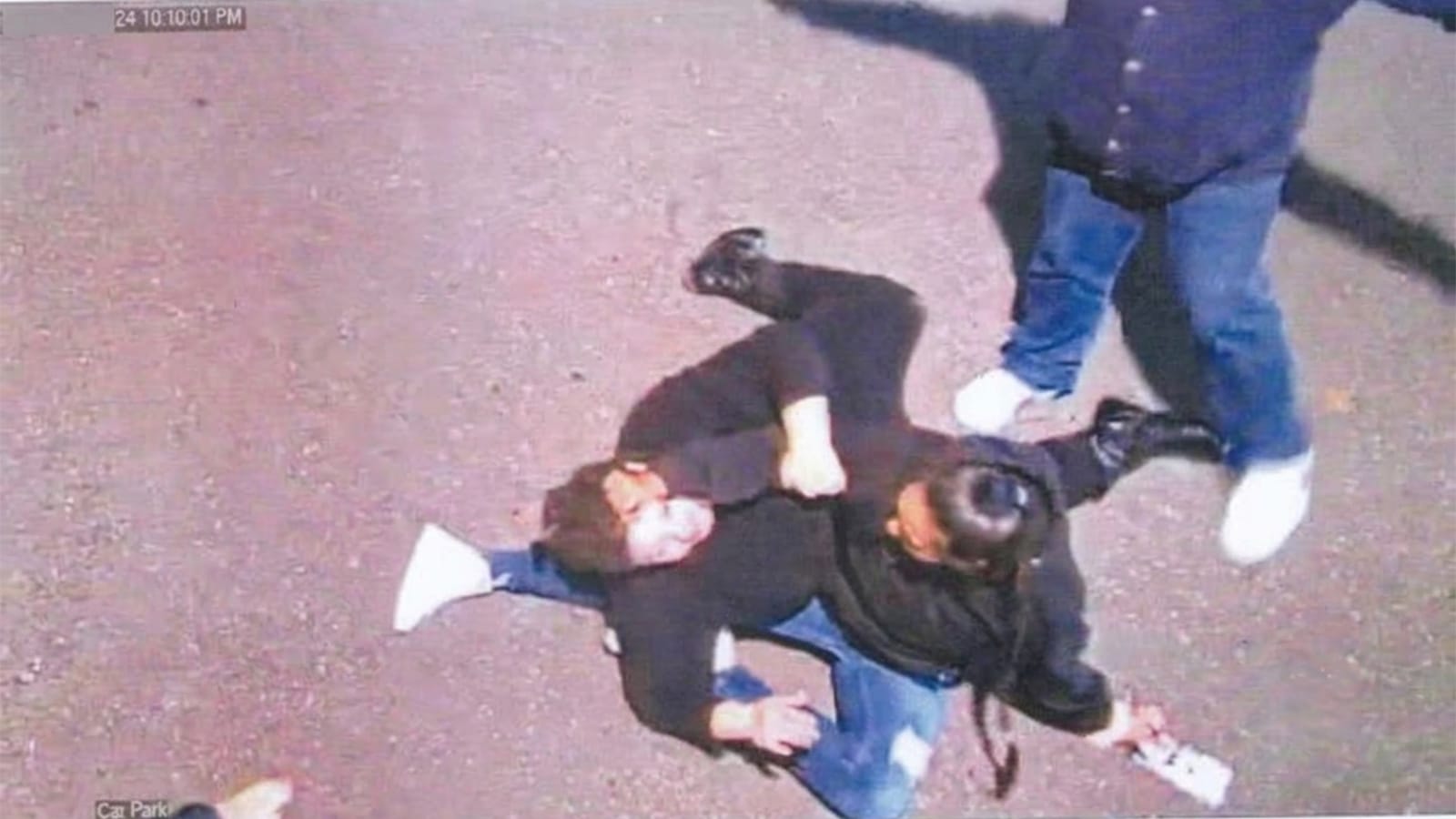 CCTV still of two people struggling on the ground