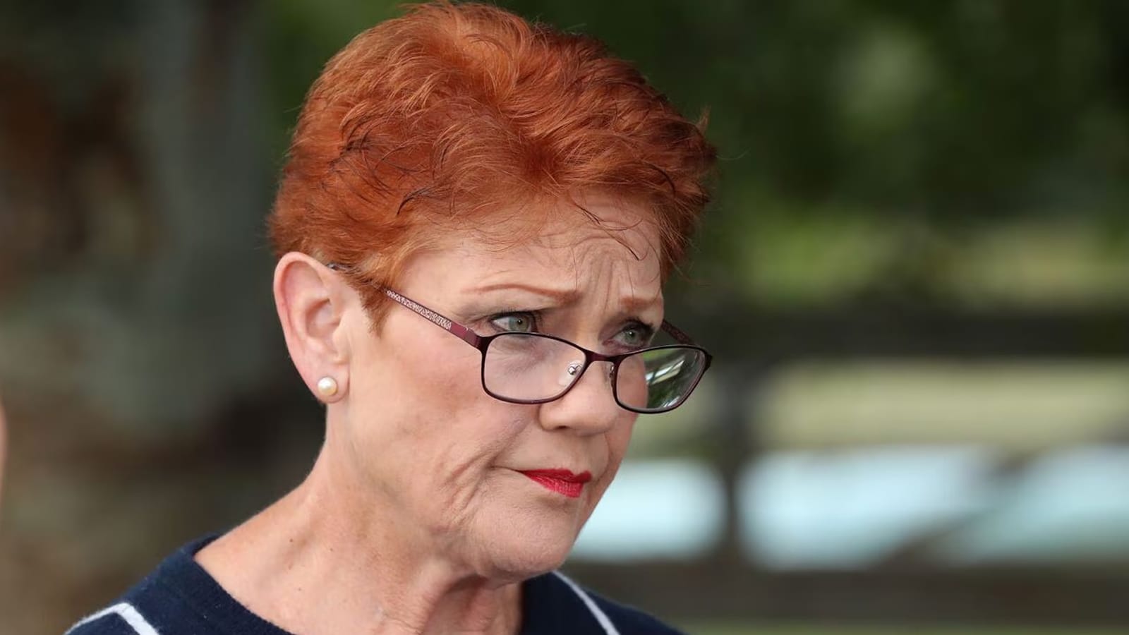 Pauline Hanson looking downcast outdoors after the court ruling