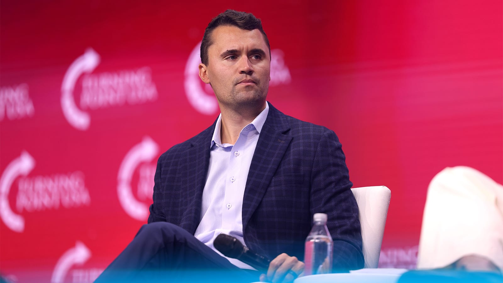 Charlie Kirk seated at a Turning Point USA event