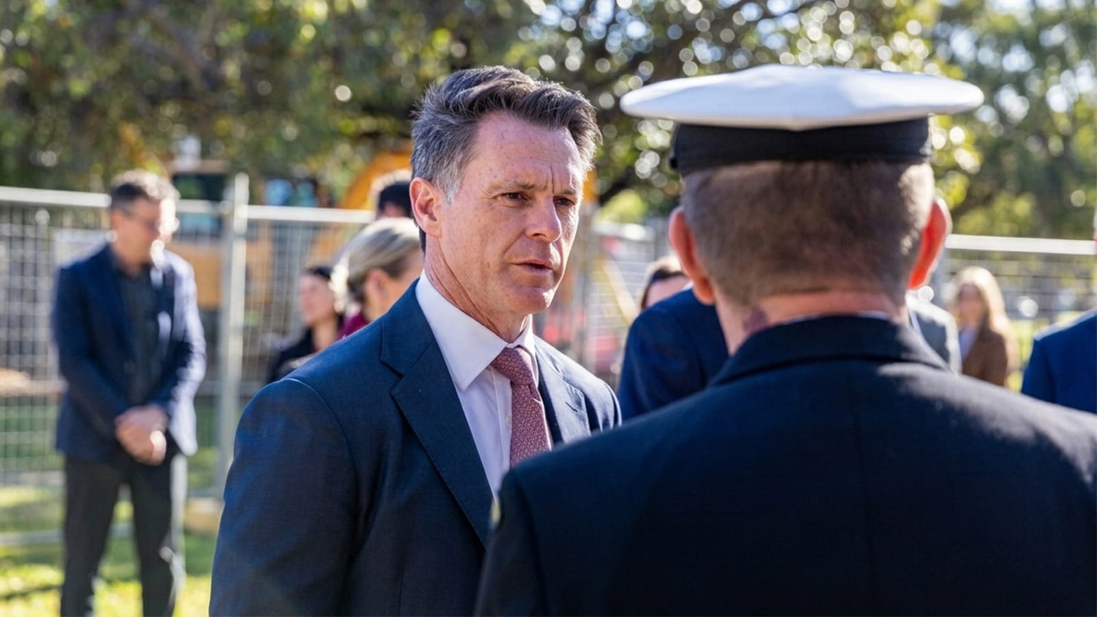 Chris Minns speaking with a uniformed officer at an outdoor event