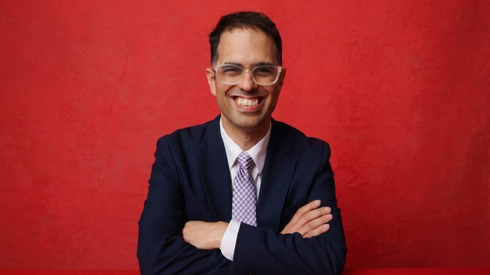 Daniel Mookhey, NSW Treasurer, in a posed portrait with folded arms