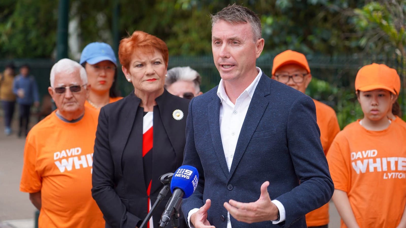 James Ashby speaking to media with Pauline Hanson standing behind him