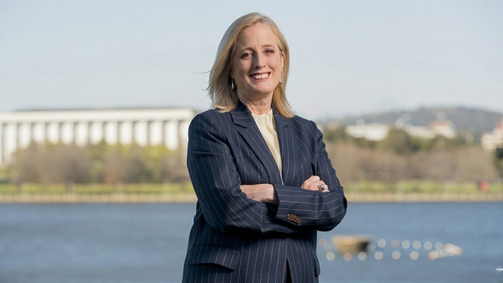 Katy Gallagher with her arms folded beside a lake in Canberra