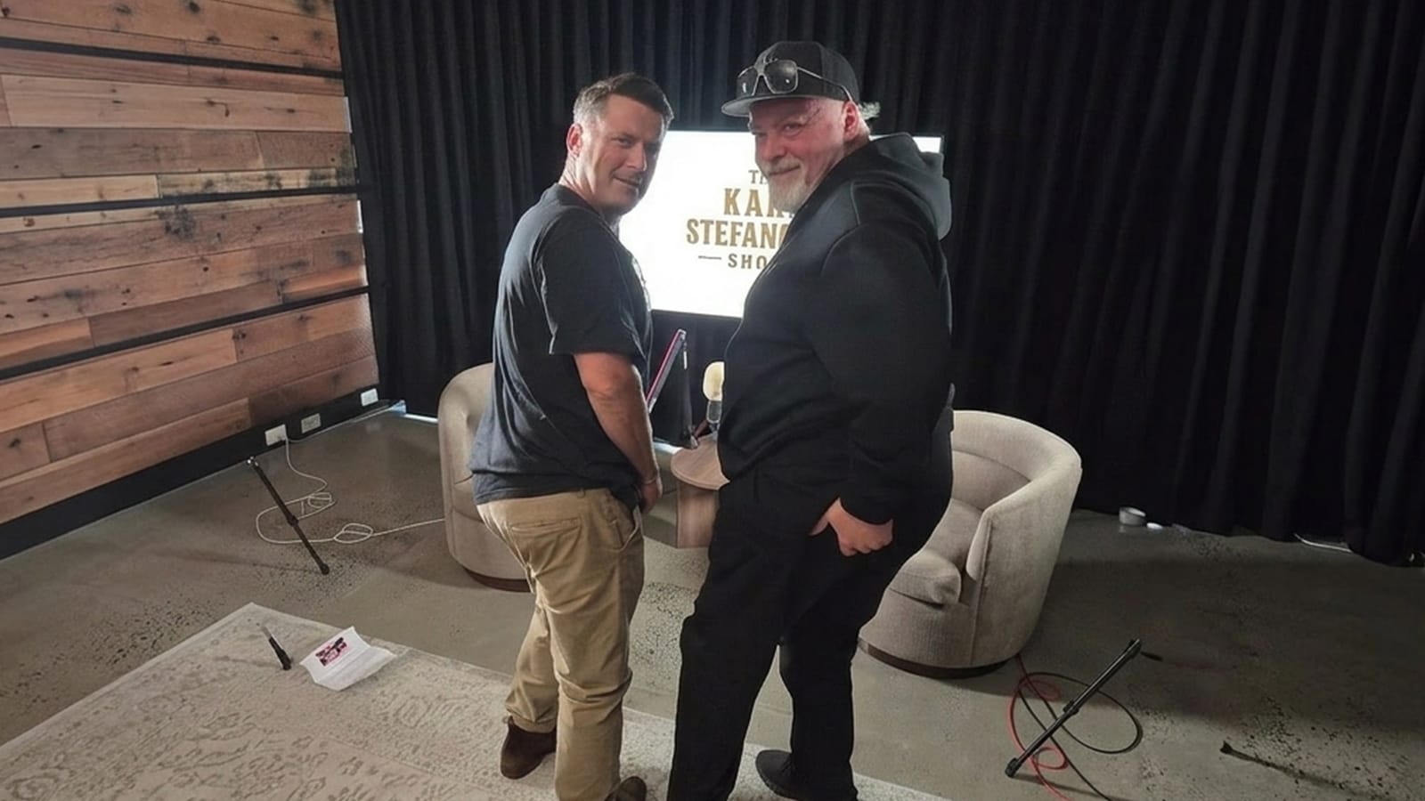 Kyle Sandilands talking to Karl Stefanovic across a table during the podcast.