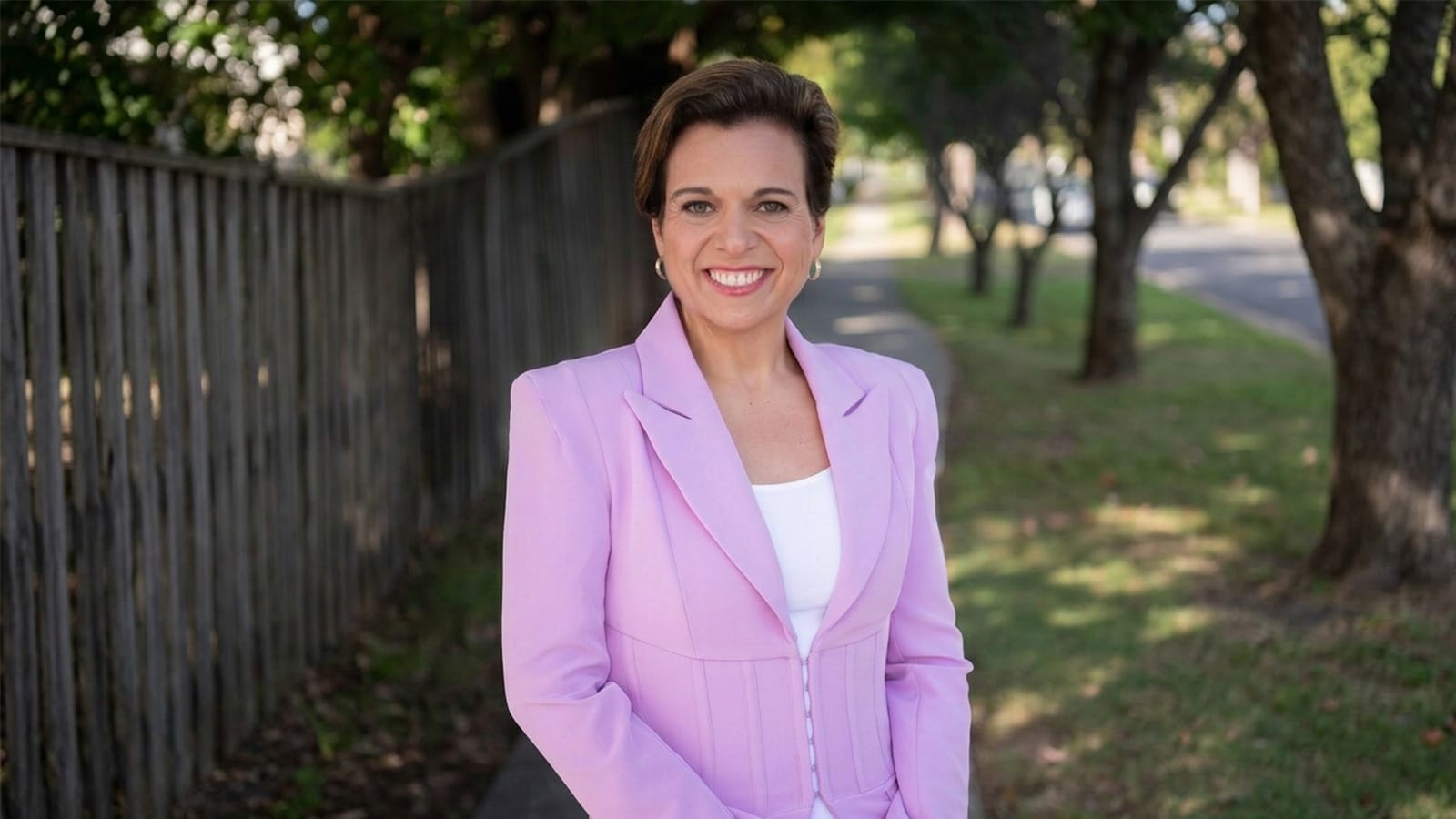 Attorney-General Michelle Rowland standing on a suburban footpath in a pink blazer