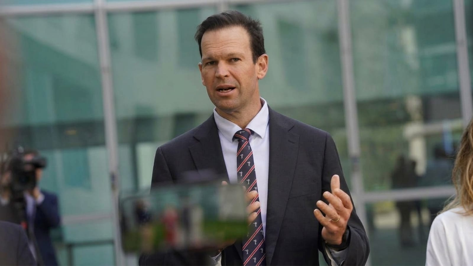 Matt Canavan speaking to reporters outside a glass fronted building