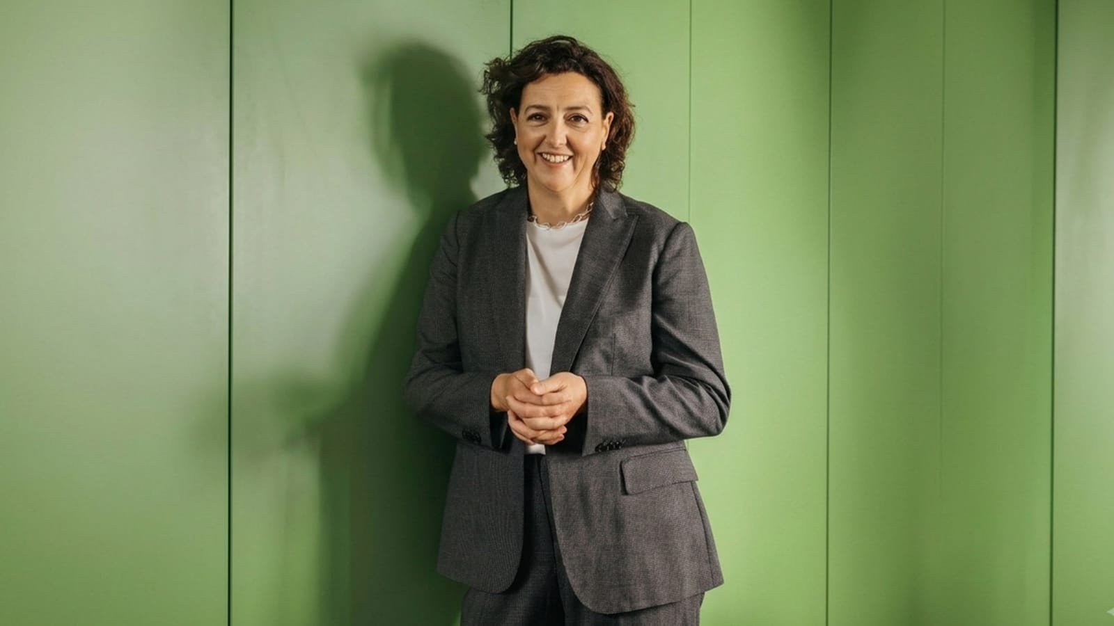 Independent MP Monique Ryan in a grey suit against a green wall