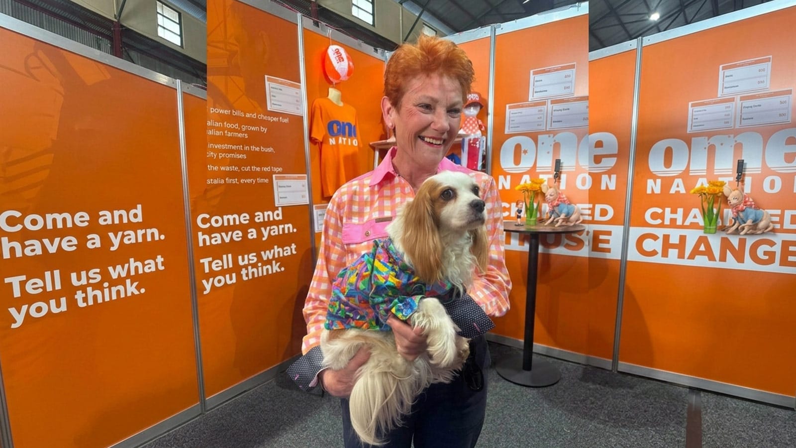 Pauline Hanson holding a small dog at the One Nation Ekka stall