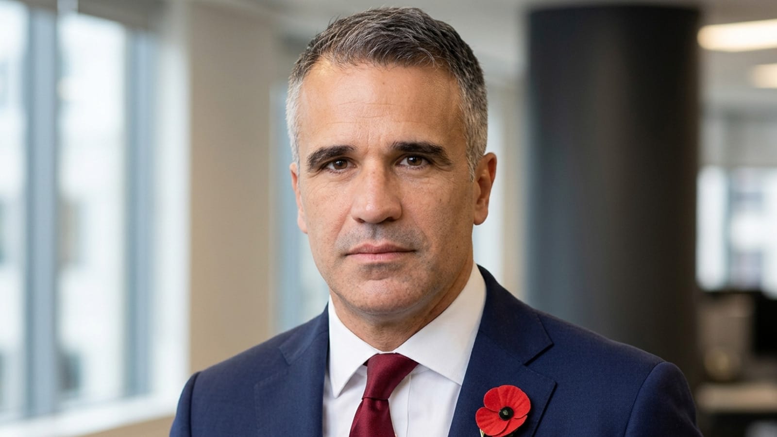 Peter Malinauskas in a navy suit wearing a red poppy pin.