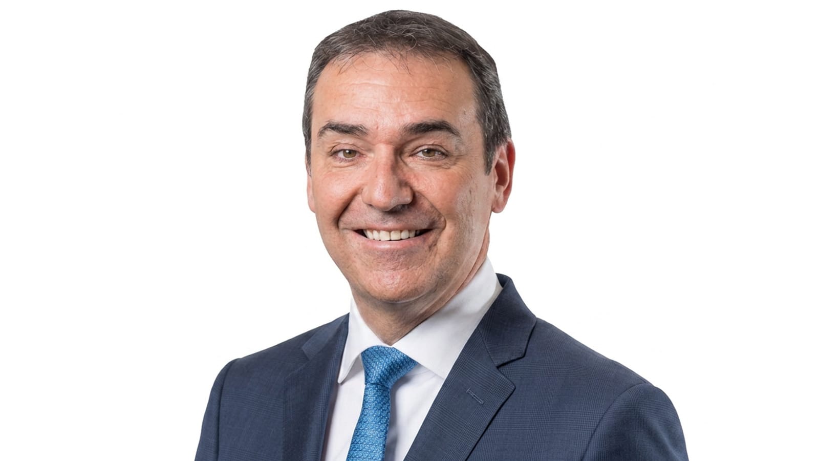 Steven Marshall in a navy suit and blue tie, studio portrait.