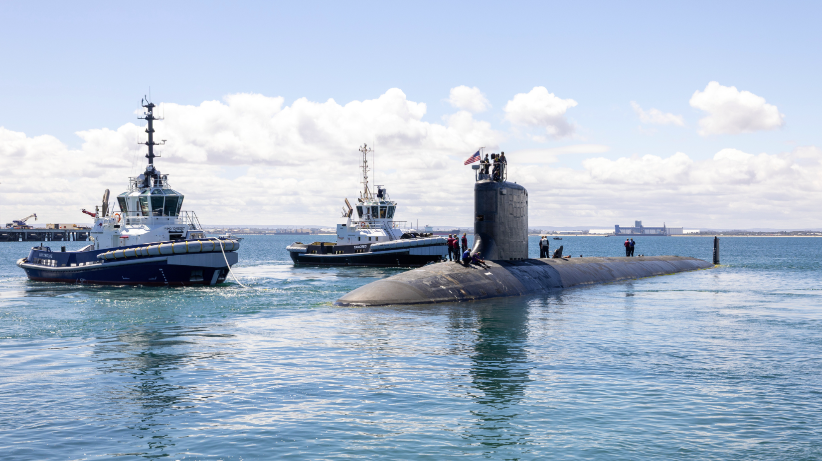 USS Vermont submarine leaving HMAS Stirling escorted by two tugboats