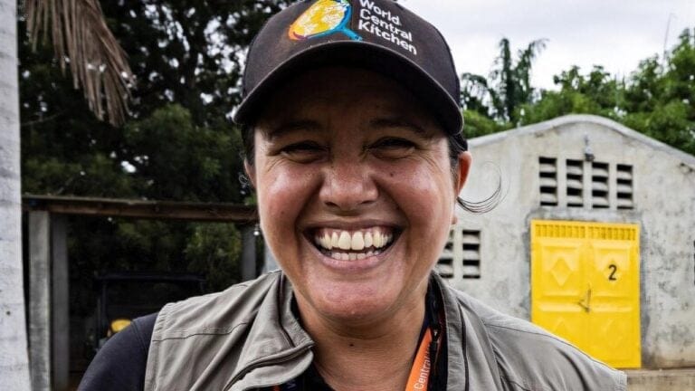 Zomi Frankcom smiling in a World Central Kitchen cap