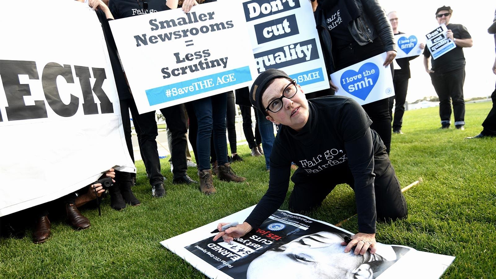 Cathy Wilcox writes on a protest placard outside Parliament House
