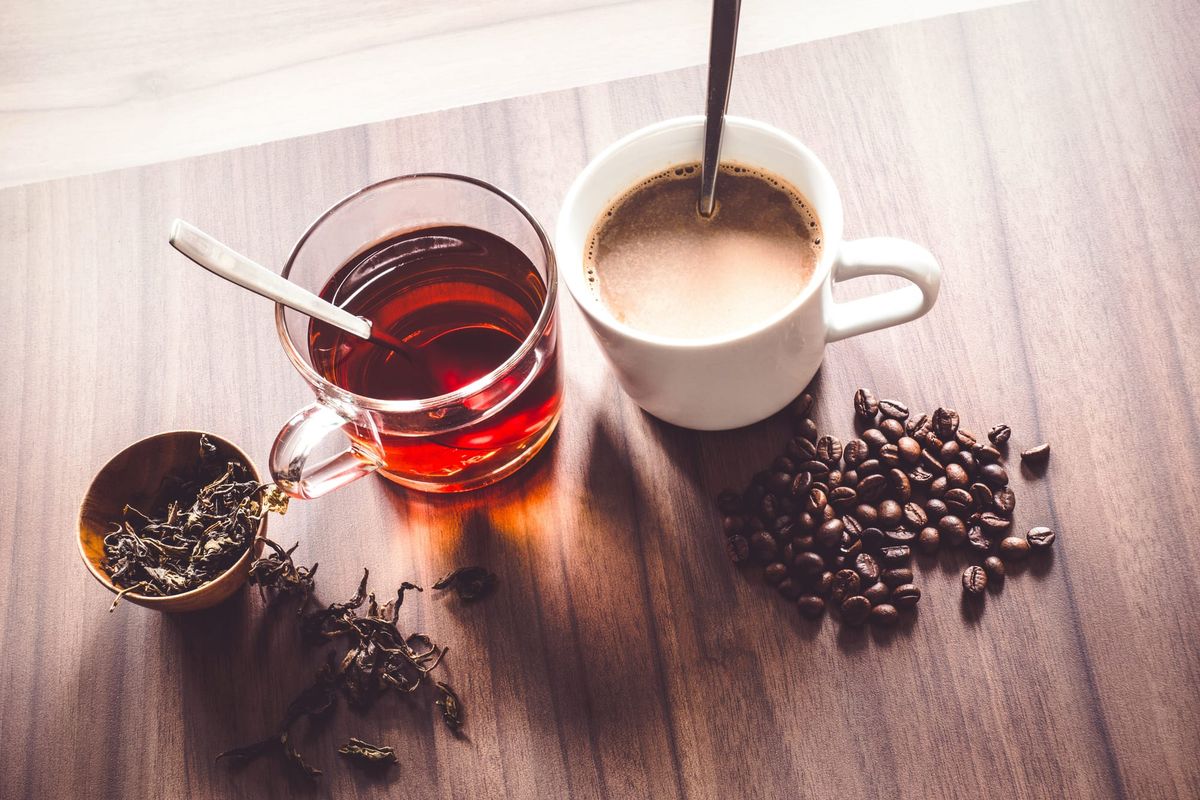Tea leaves, coffee beans, cup of tea and cup of coffee