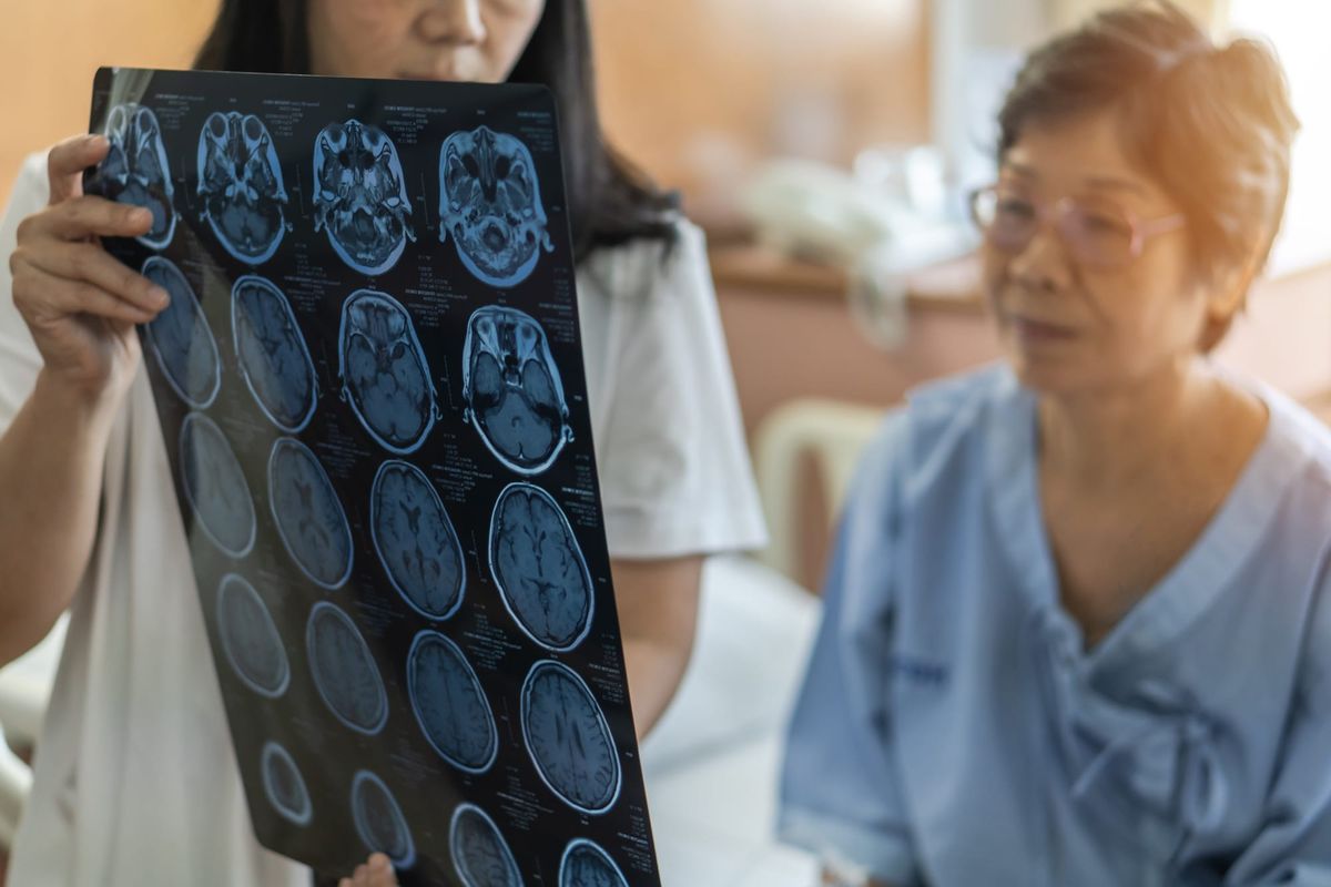Patient reviewing brain scans with medical practitioner.