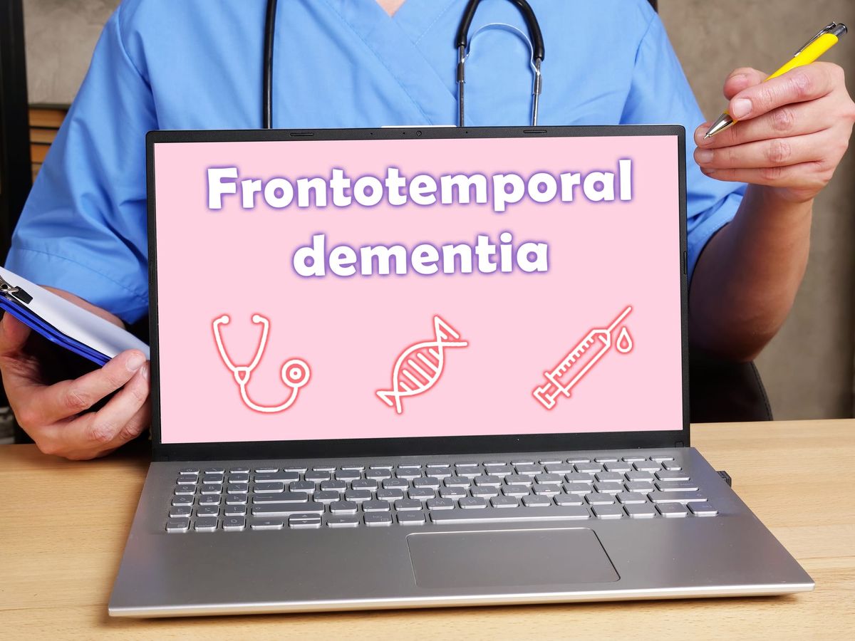 Health care professional displays open laptop with the words frontotemporal dementia on the screen.