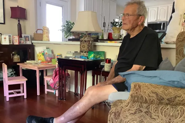 An older man sits in a recliner in his living room.