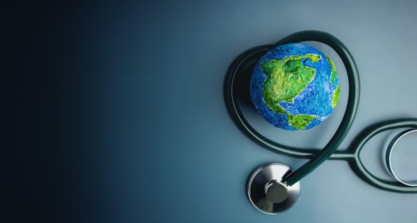 Stethescope wrapped in the shape of a heart around a painted globe.  