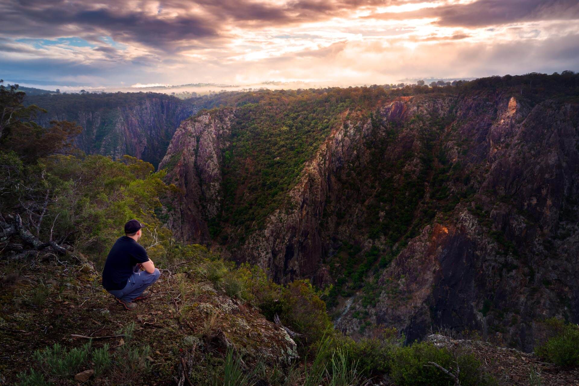 Hiker overlooking dramatic valley in Oxley Wild Rivers NP