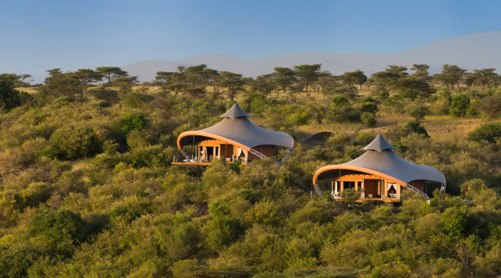 A scenic view of Mahali Mzuri lodge in Kenya, nestled amidst greenery and sprawling African plains, blending seamlessly with the natural surroundings.
