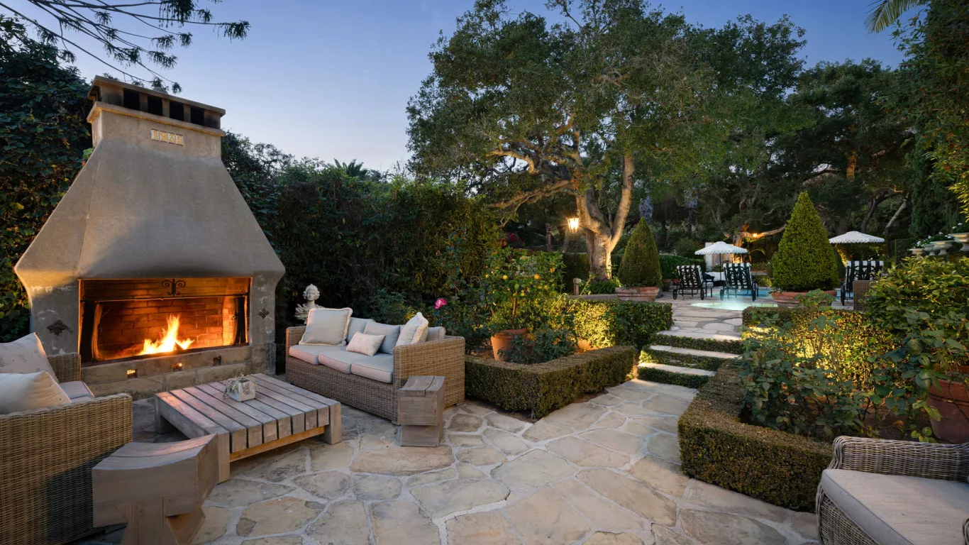 Unwind at this timeless Mediterranean-inspired poolside retreat with manicured hedges, towering palms, and verdant greenery.&nbsp;