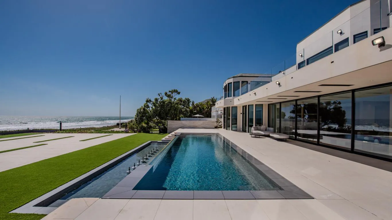 Appreciate this striking oceanfront in Malibu with an infinity pool as its focal point, overlooking a stretch of sandy beach.