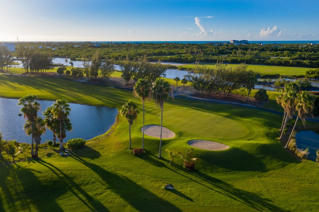 Serenity at the Royal Turks & Caicos Golf Club Alt text: Immaculate aerial views of the golf course at Royal Turks & Caicos Golf Club, dotted with palm trees, ponds, and meticulously maintained sand bunkers.&nbsp;&nbsp;