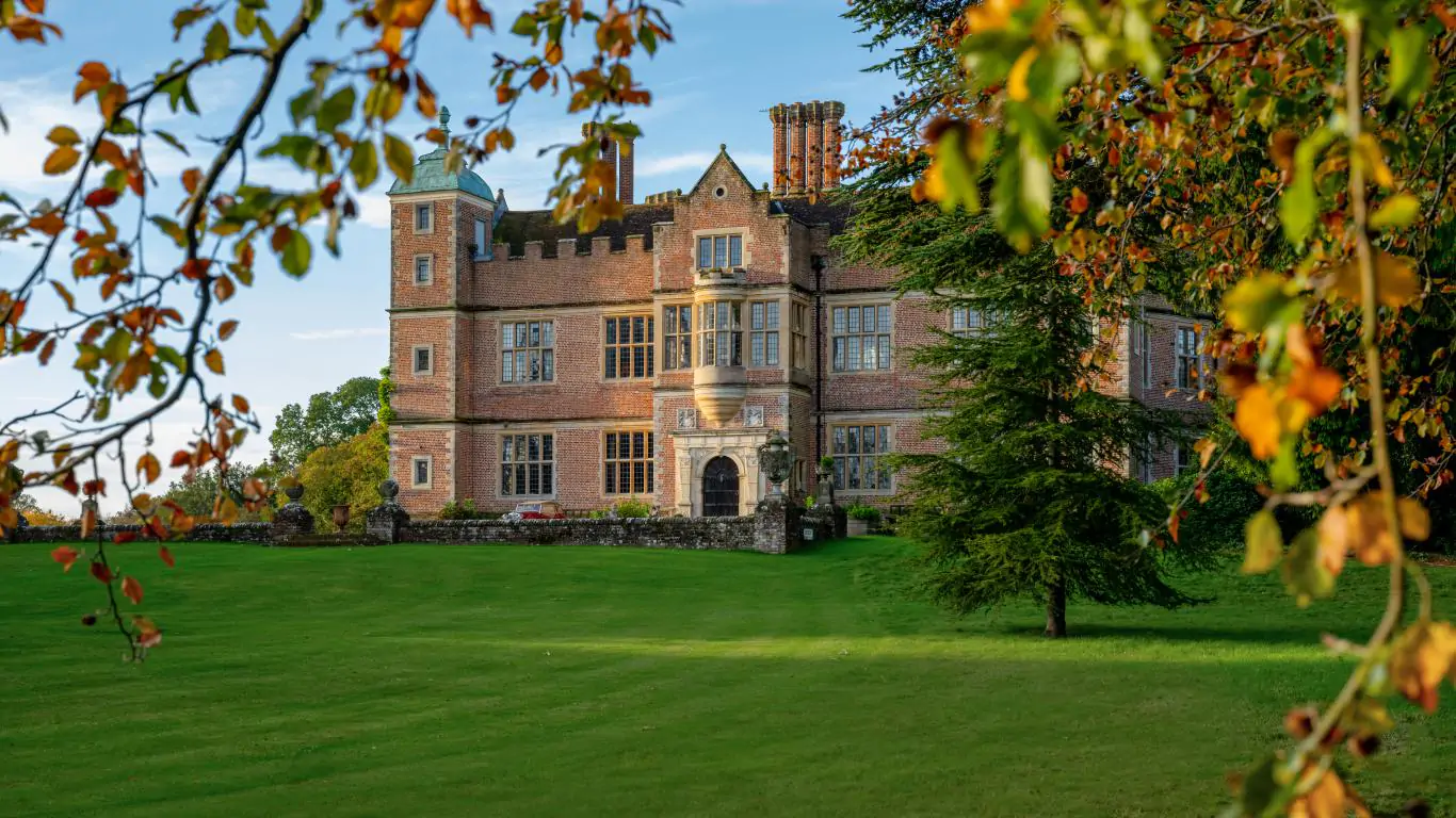 A majestic view of Chilham Castle as its grand Elizabethan facade bathes in golden light.