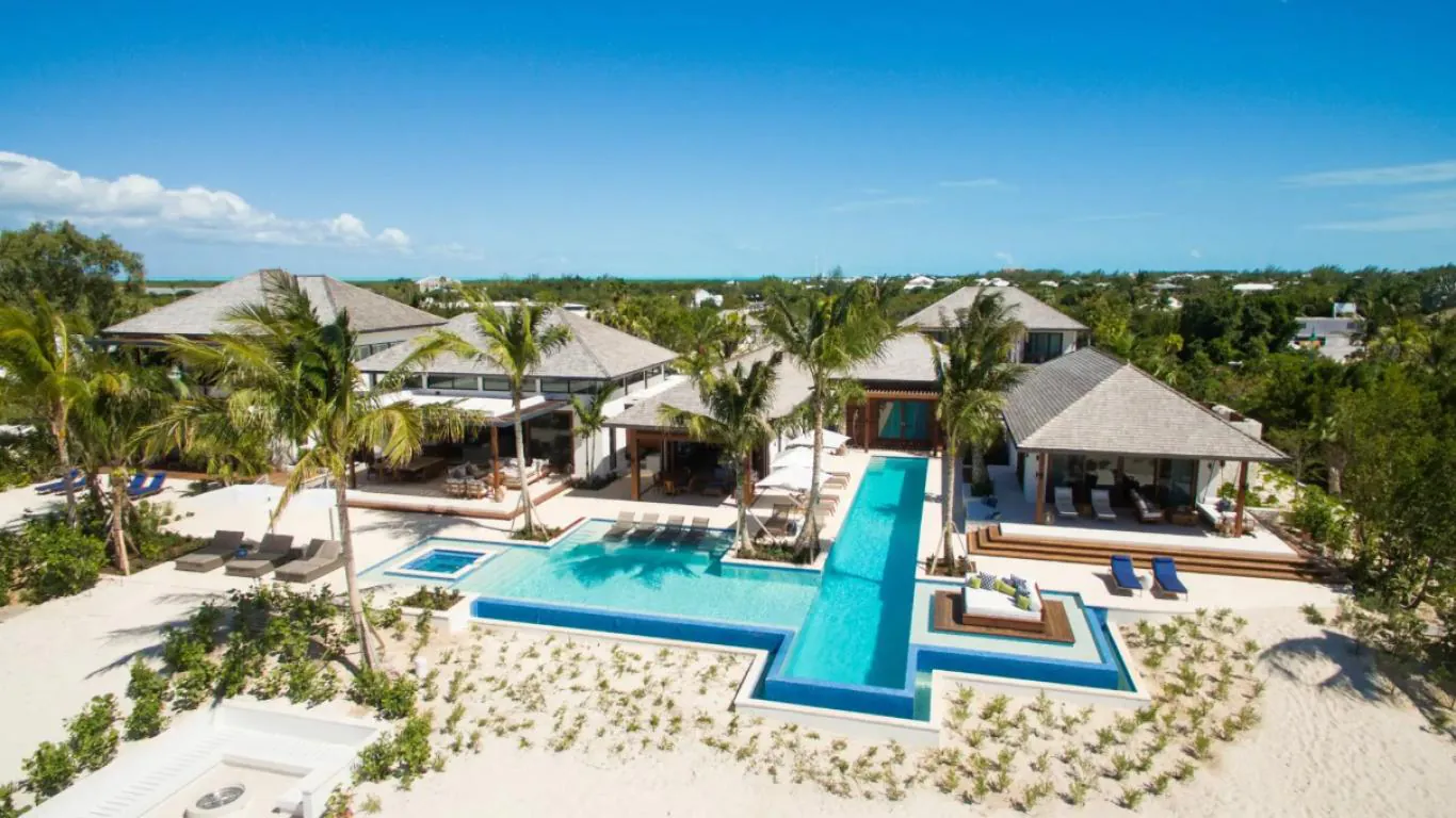Exquisite beachfront estate - Hawksbill Estate Alt text: An opulent beachfront villa, Hawksbill Estate in Turks and Caicos, featuring multiple modern pavilions, a geometric infinity pool, and verdant tropical surroundings with direct access to white sand beaches.&nbsp;