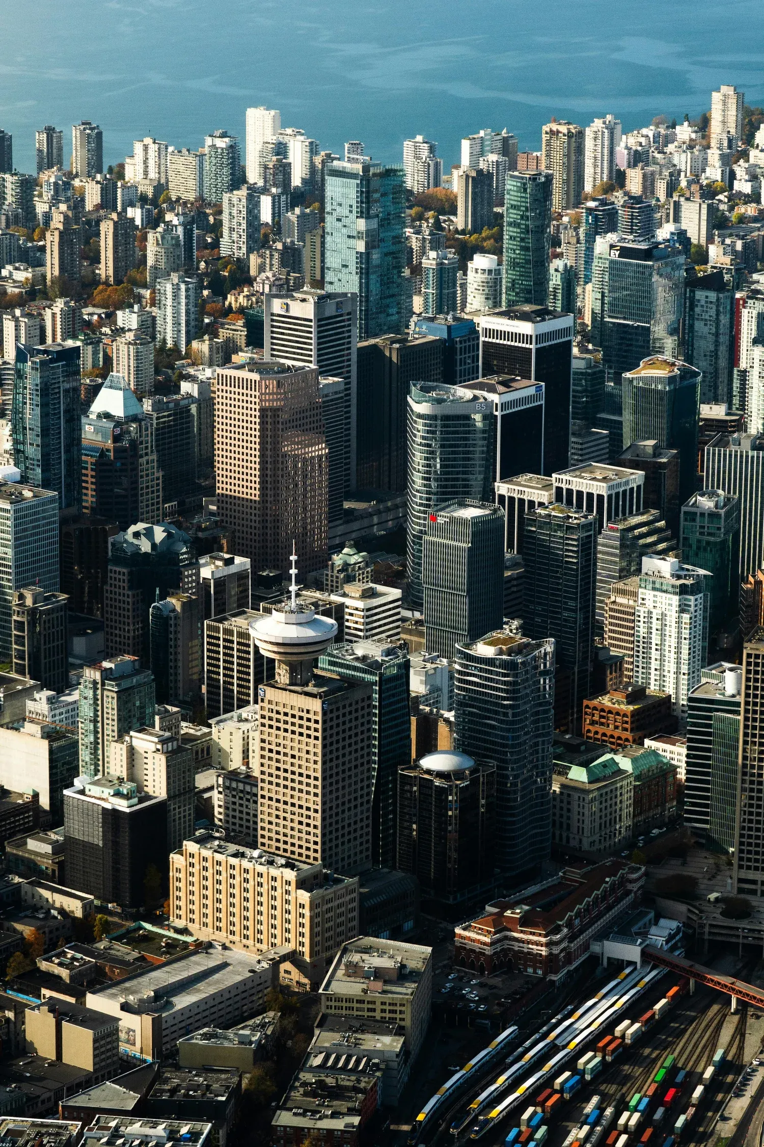 Aerial photograph of British Columbia land — coastline and forested suburban blocks.
