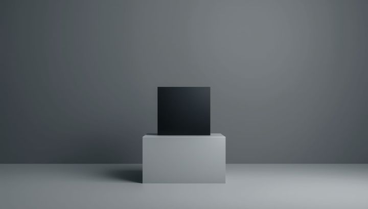 A perfect, simple, matte black cube on a white pedestal.
