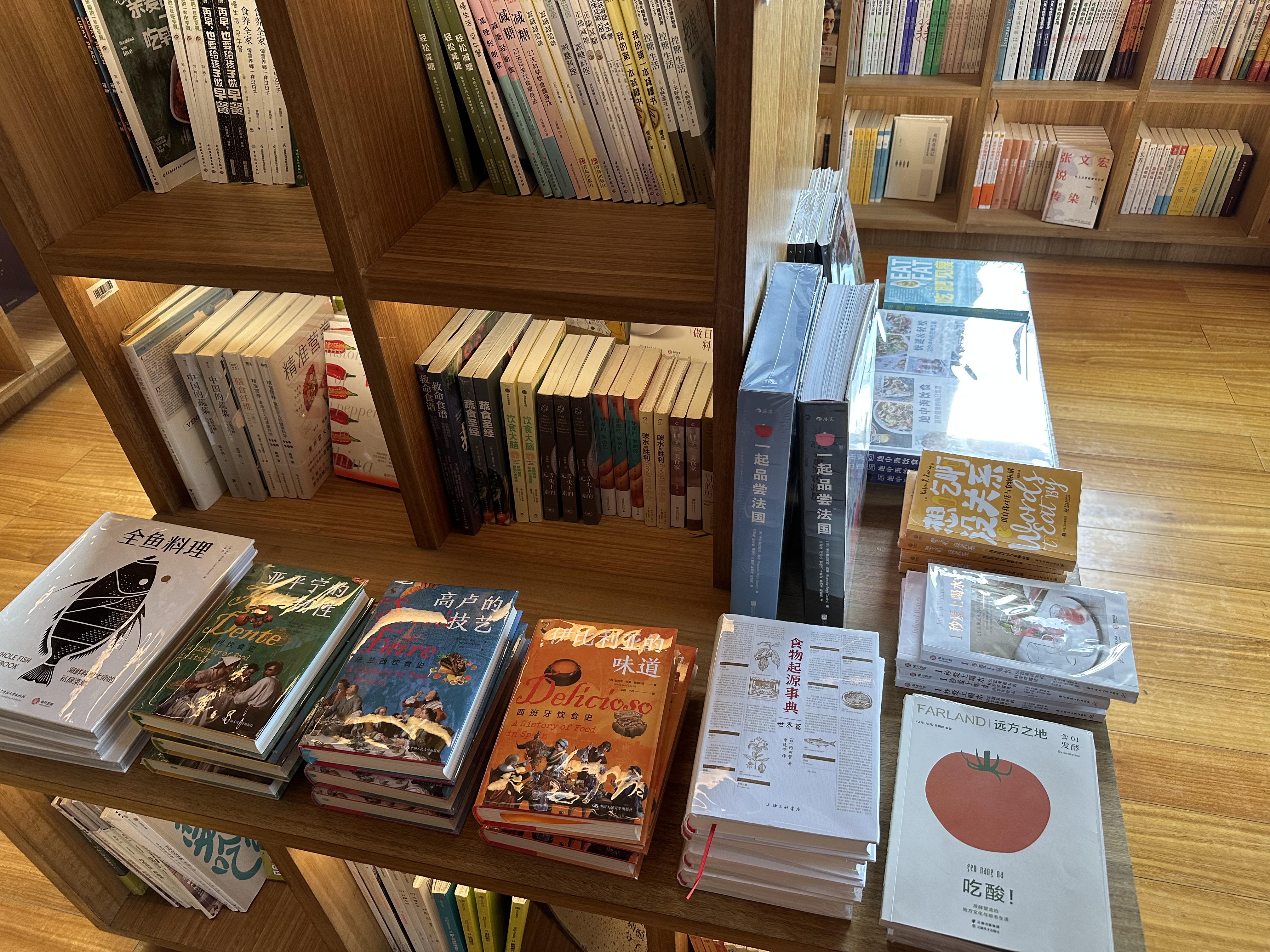 A 4x4 area-book shelf on a table, surrounded by books. In the far right corner, a book known as Chi Suan! written by Snout & Seek co-founders sits.