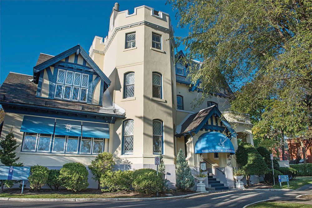 Old Canadian architecture, the Le Cordon Bleu campus in Ottawa, Ontario, Canada sits atop a hill near downtown, looking similar to a beige and blue castle.