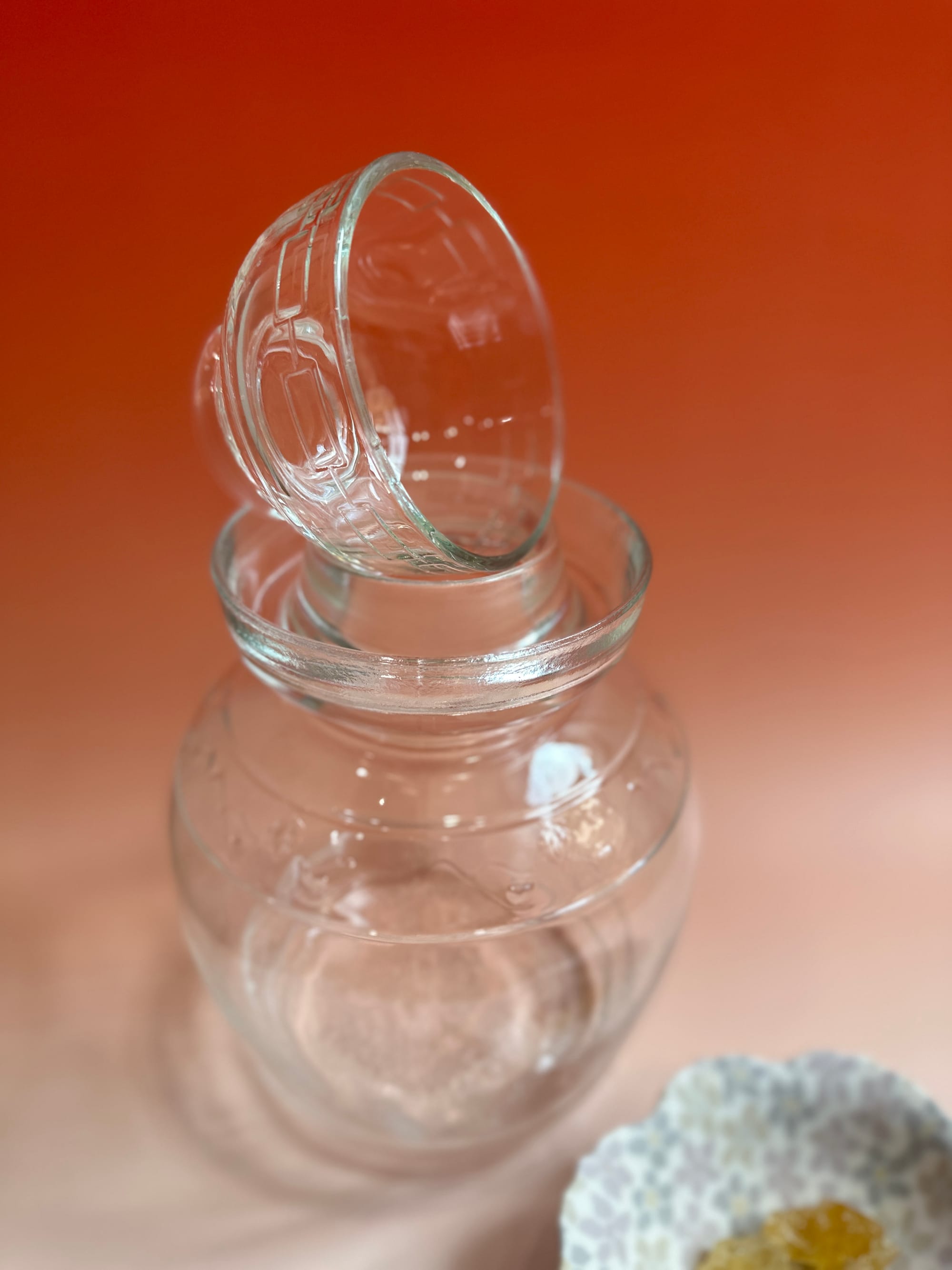 An empty glass pickling jar with lid resting on top.