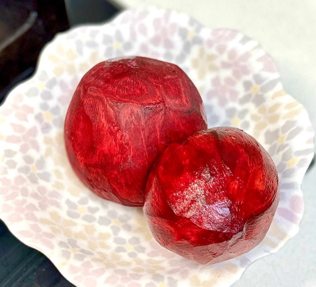 Peeled red beetroots, crimson red, on a white dish with pink and beige polka dots