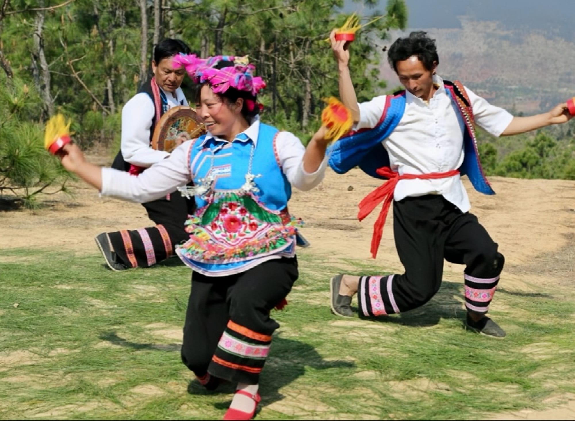 Three Yi dancers mid dance.