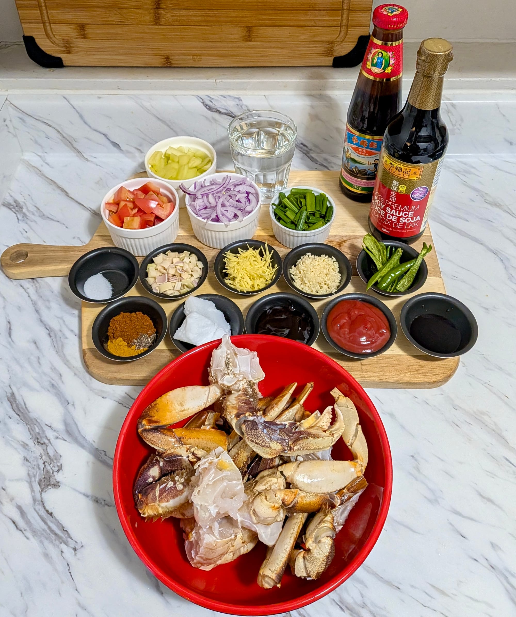 Portioned spices, diced vegetables, sauces, and crabs laid out for Deviled Crab.